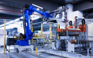"Blue industrial robotic arm operating in modern manufacturing facility, working with automated assembly line equipment including orange and white machinery components in clean, well-lit factory environment with safety barriers and industrial infrastructure visible in background"