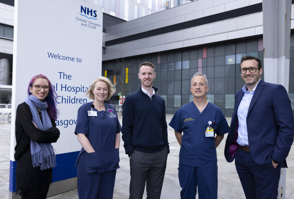 Five members of the Seluna and NHS clinical team standing outside the Royal Hospital for Children, NHS Greater Glasgow and Clyde. Left to right: Dr Yola Jones of Seluna, Dr Ruth Hamilton (Consultant Clinical Scientist), Dr Scott Black (CEO of Seluna), Prof Haytham Kubba (Paediatric ENT Surgeon), and Innes Taylor (Commercial Manager at Seluna).
