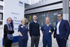 Five members of the Seluna and NHS clinical team standing outside the Royal Hospital for Children, NHS Greater Glasgow and Clyde. Left to right: Dr Yola Jones of Seluna, Dr Ruth Hamilton (Consultant Clinical Scientist), Dr Scott Black (CEO of Seluna), Prof Haytham Kubba (Paediatric ENT Surgeon), and Innes Taylor (Commercial Manager at Seluna).