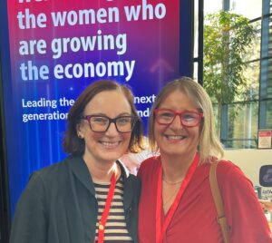 Wendy and Sarah Lee smiling together in front of a screen celebrating women growing the economy at a NatWest event, photo via Hot Tin Roof PR agency